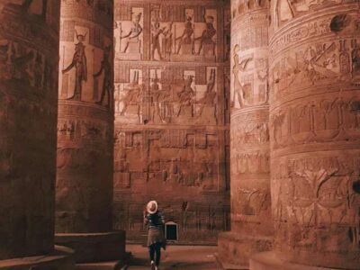 a tourist looking at pillars inside the dendera temple